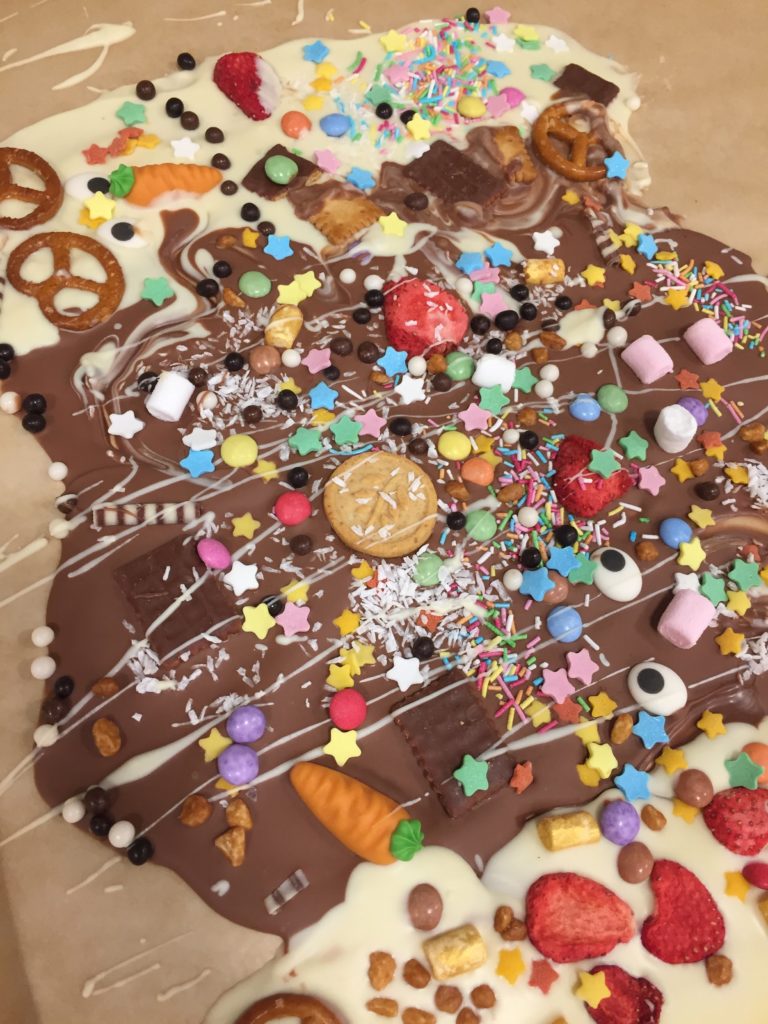 Kunterbunte Bruchschokolade als Geschenk wird im Workshop für Kinder gestaltet