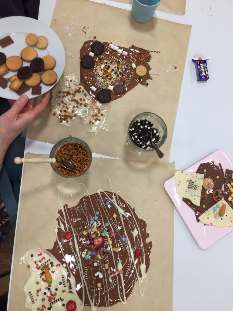 Kunterbunte Bruchschokolade als Geschenk wird im Workshop für Kinder gestaltet