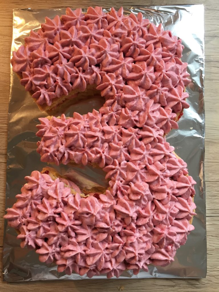 Der Number-Cake wird mit Quark-Sahne-Röschen dekoriert.
