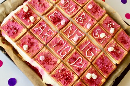 Mit Butterkeks dekorierter Himbeer-Blechkuchen als selbstgerechtes Geschenk für den Muttertag.