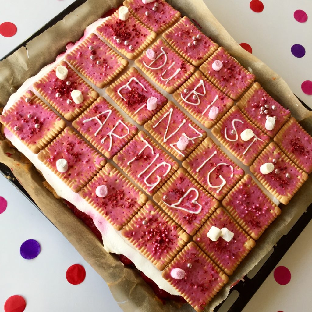 Mit Butterkeks dekorierter Himbeer-Blechkuchen als selbstgerechtes Geschenk für den Muttertag.