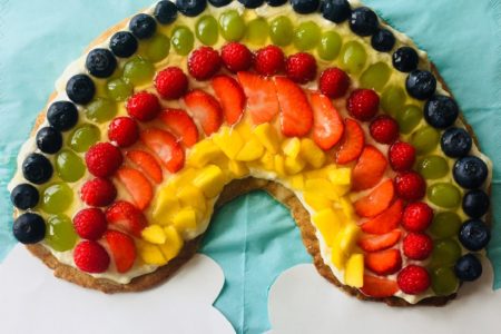 Regenbogenkuchen mit fruchtiger Dekoration