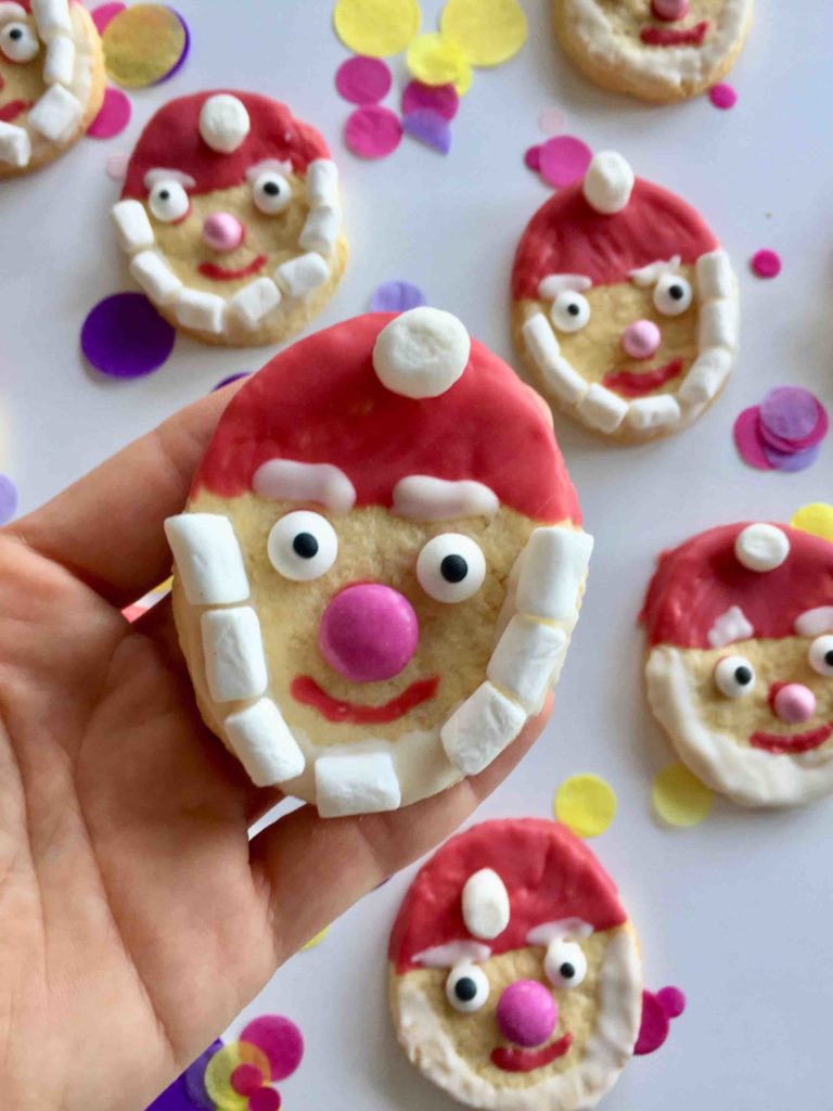 Ein Nikolaus Plätzchen mit roter Mütze und weißem Marshmallow-Bart. Die Santa Claus Cookies sind perfekt für das Backen mit Kindern.