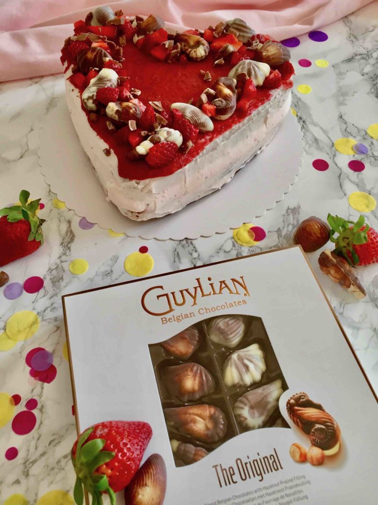 Die Erdbeeren-Quark-Torte zum Muttertag wird mit köstlichen Guylian-Pralinen gekrönt.