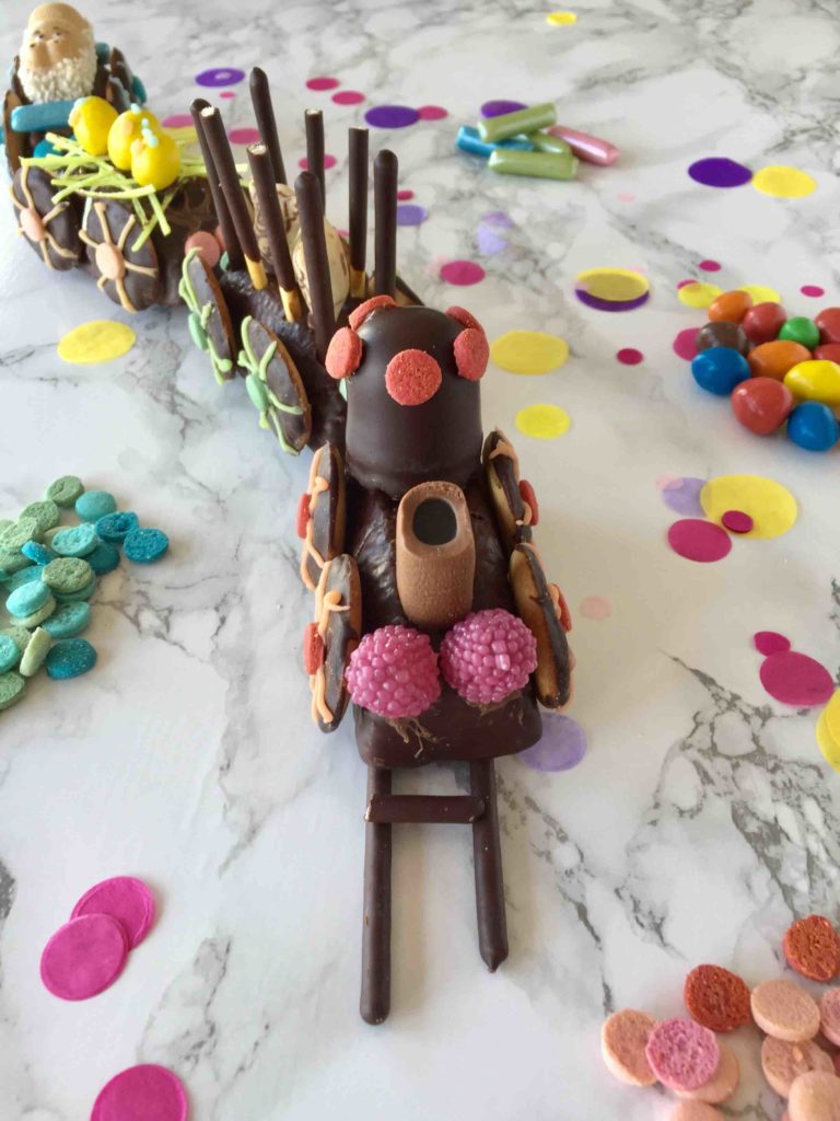 Der kunterbunte Eisenbahnkuchen für den Kindergeburtstag wird mit Süßigkeiten farbenfroh dekoriert.