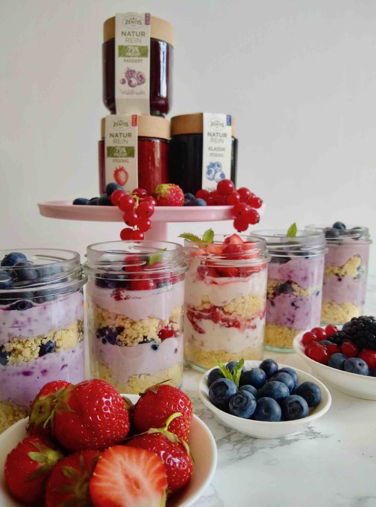 Fruchtige No-Bake-Cakes im Glas mit verschiedenen Beeren - eine schnelle Picknickidee zum Selbermachen mit Kindern