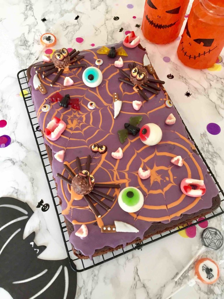 Unser saftiger Schokoladenkuchen als kunterbunter Candycake für Halloween dekoriert.