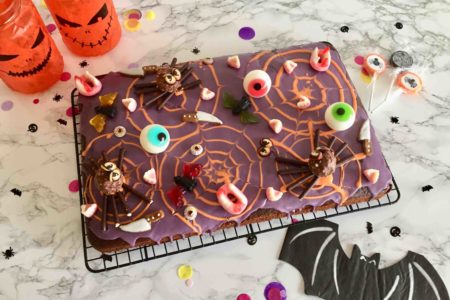 Unser saftiger Schokoladenkuchen als kunterbunter Candycake für Halloween dekoriert.