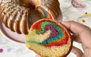 Der Surprise Cake mit verstecktem Regenbogen sieht von außen aus wie ein ganz normaler Geburtstagskuchen, dabei ist er ein kunterbunter Regenbogenkuchen.