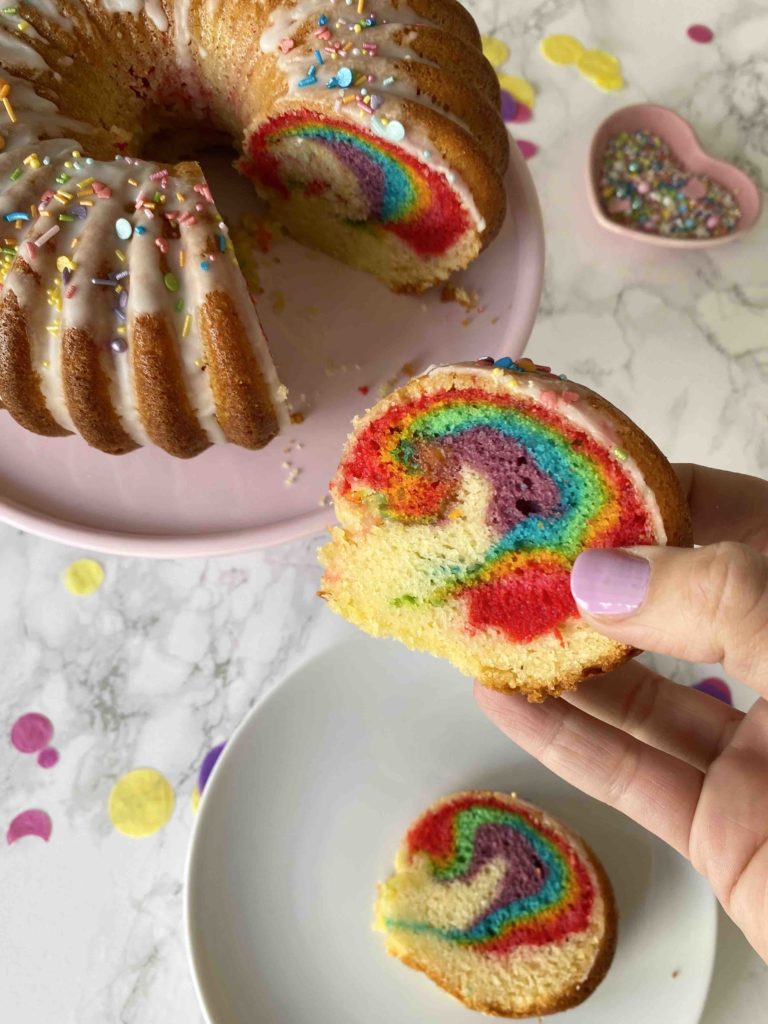Der Surprise Cake mit verstecktem Regenbogen sieht von außen aus wie ein ganz normaler Geburtstagskuchen, dabei ist er ein kunterbunter Regenbogenkuchen.