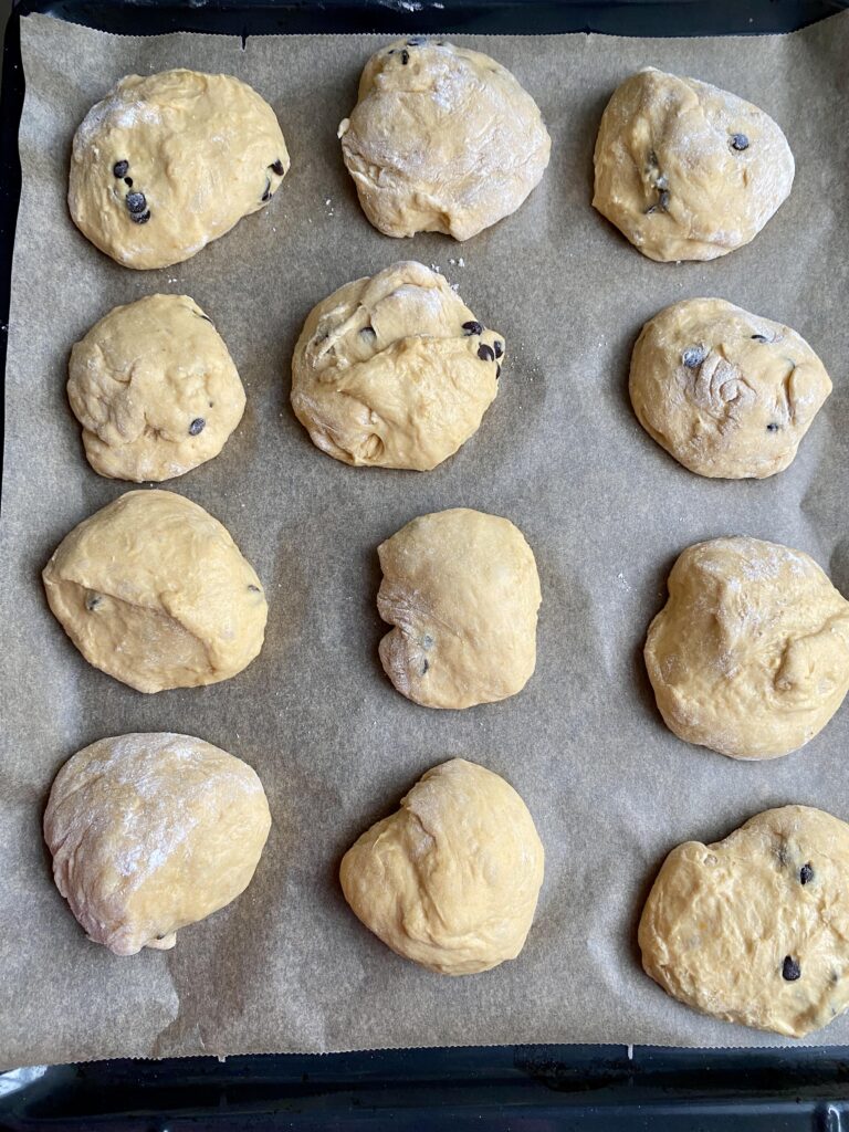 Der Hefeteig wird in kleine Kugeln aufgeteilt, die anschließend die Kürbis-Schokobrötchen ergeben.